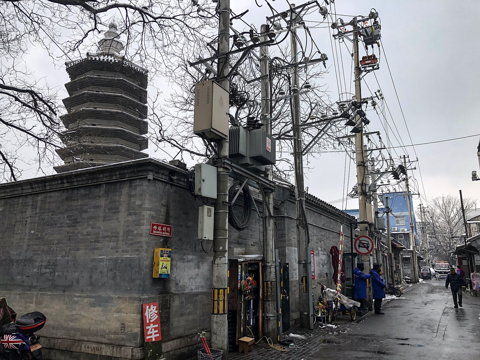 Quiet Beijing hutong lane with grey brick walls in morning light