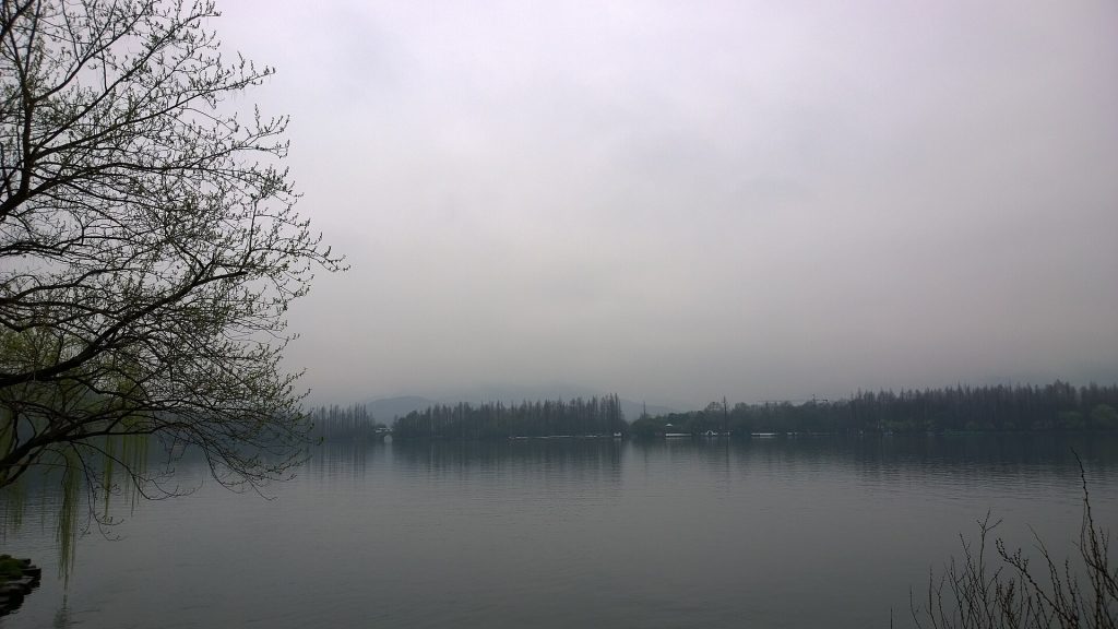 Misty morning at Hangzhou West Lake with willows and still water