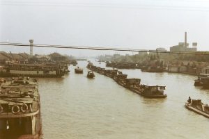 Misty Suzhou canal with stone bridge and whitewashed houses at dawn