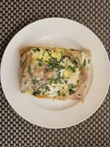Fresh jianbing savory crepe folded on paper at a street breakfast stall