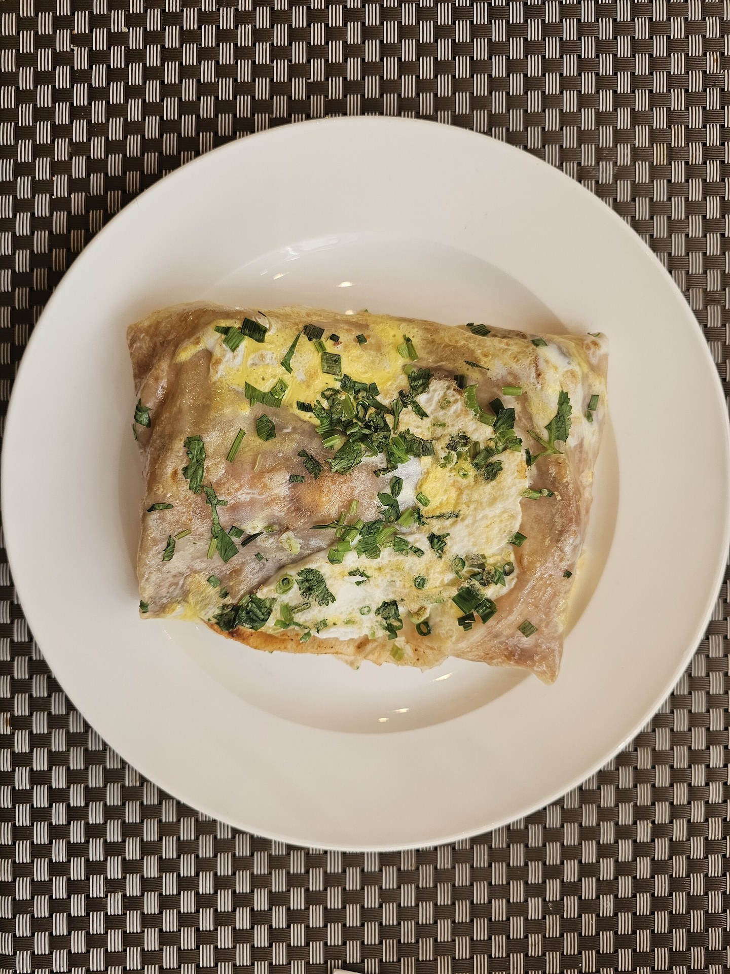 Fresh jianbing savory crepe folded on paper at a street breakfast stall