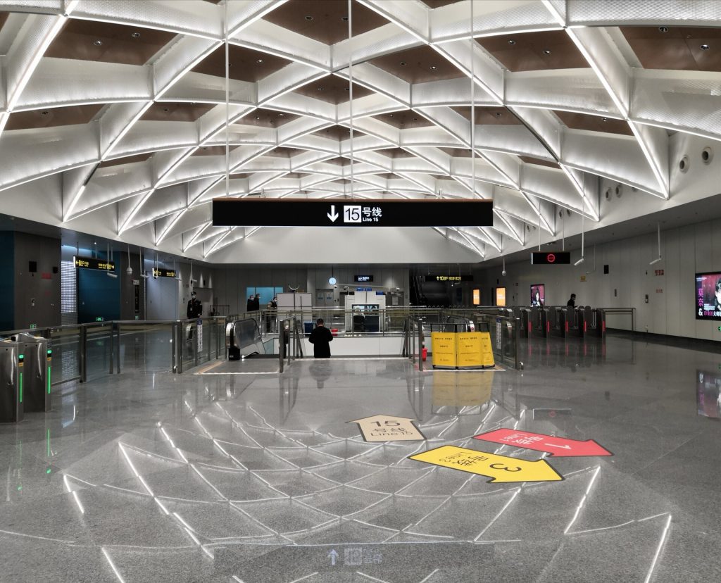 Shanghai Metro station concourse with signage and passengers near ticket gates