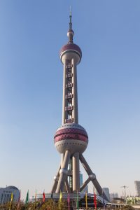 Shanghai Oriental Pearl Tower illuminated at dusk beside the Huangpu River