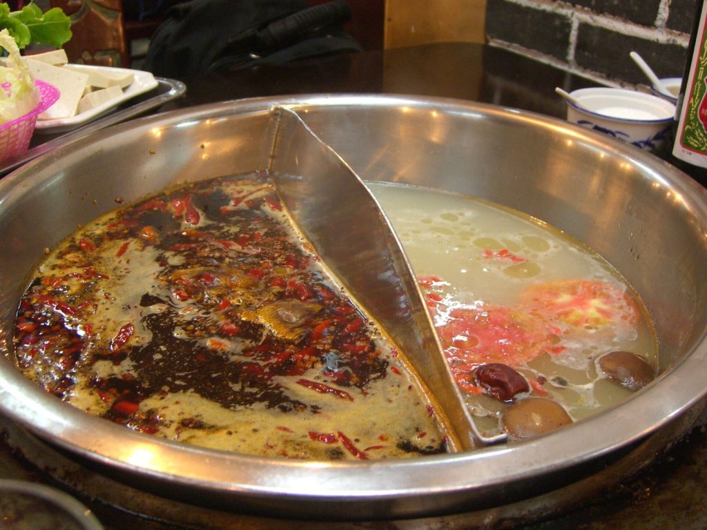Sichuan hotpot table with chili oil, peppercorns, and dipping sauces
