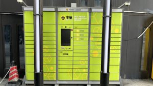 Yellow-green Hive Box parcel pickup lockers at a building entrance in Dongguan, Guangdong