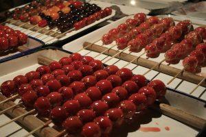 Skewers of glossy candied hawthorn tanghulu at a market stall