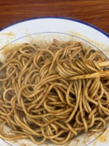 Bowl of Wuhan hot dry noodles with sesame sauce and pickled vegetables
