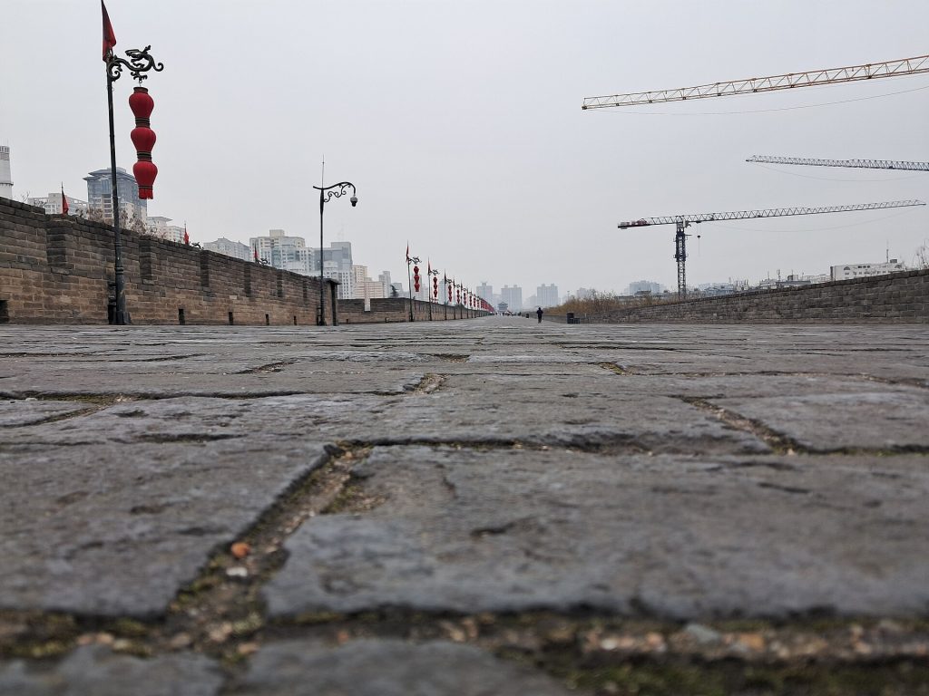 Ancient Xi'an city walls with brick battlements and a watchtower under blue sky